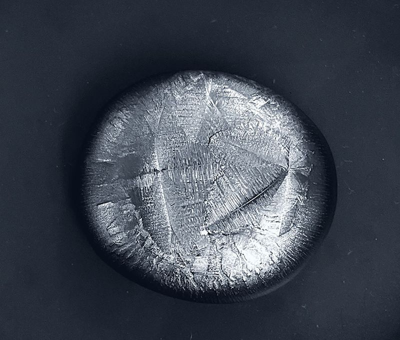 An as-cast alloy button showing its dendritic surface